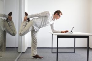 Man staying healthy exercising in front of desk